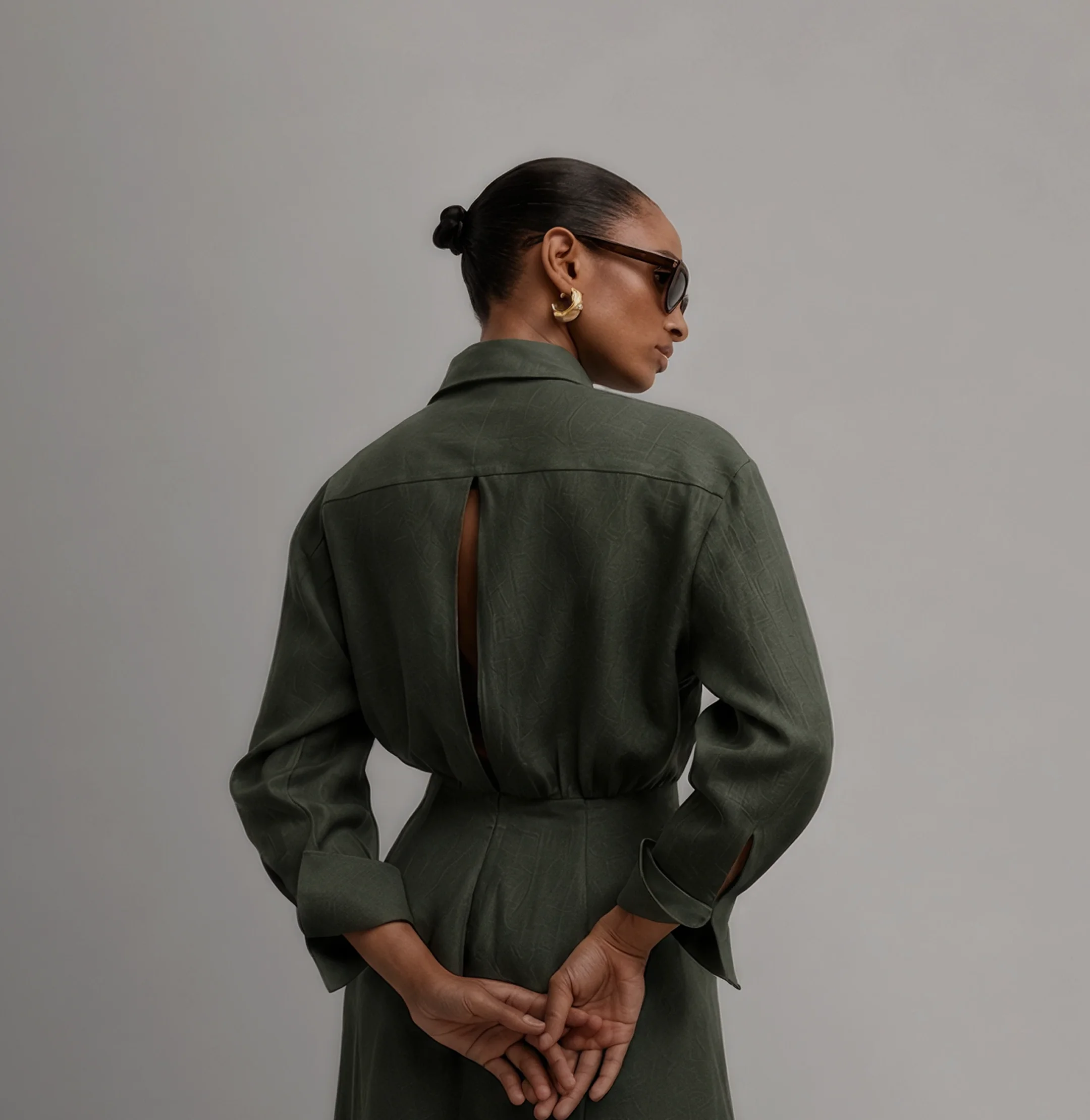 Woman in an olive green shirt dress, back view